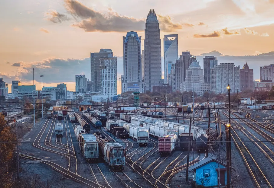 The uptown Charlotte skyline rising behind a rail yard